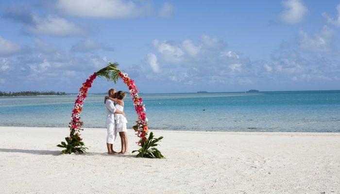 Heiraten Rarotonga - Paar unter Blumenbogen am Strand - Cook Inseln